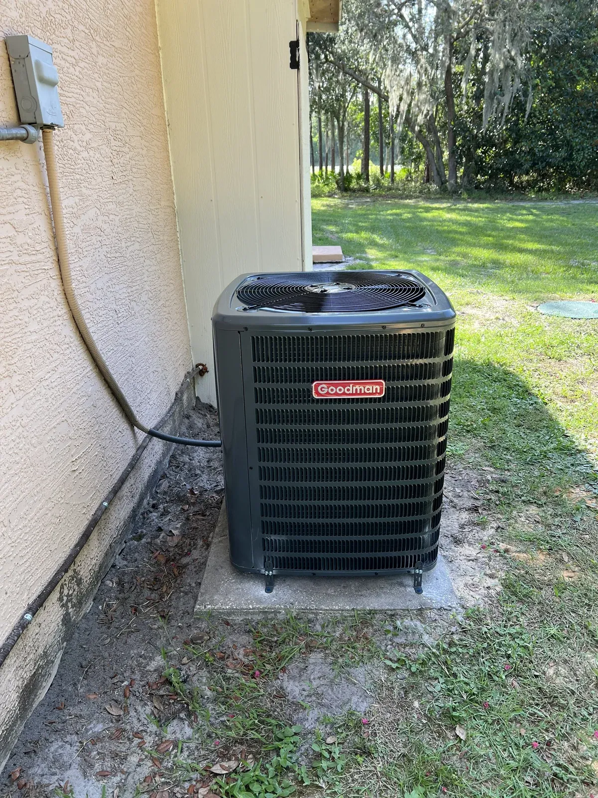 Newly installed outdoor air conditioning condenser beside a home